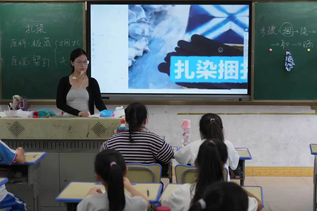 “星光引路”支教实践队志愿者为小学生讲解蓝染非遗工艺与操作步骤