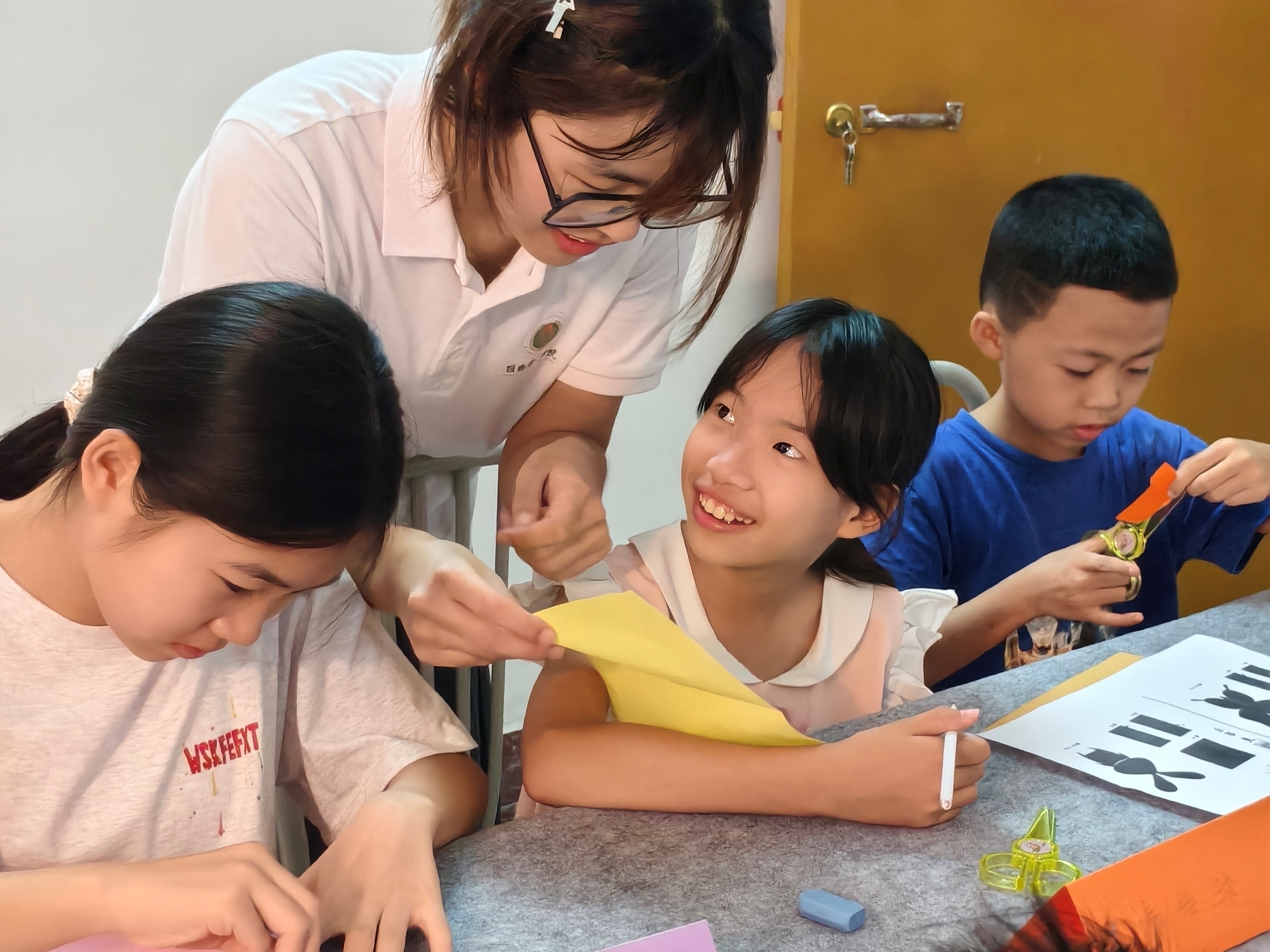 图2：队员指导小朋友体验客家剪纸非遗手工
