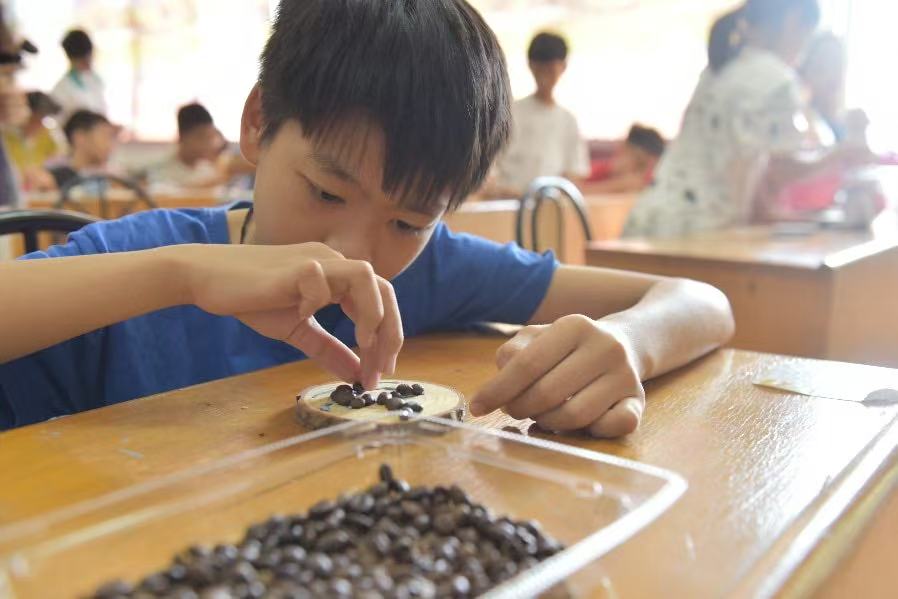 图为 孩子利用咖啡豆进行拼贴画创作，体验变废为宝的乐趣。郭榕，陈子欣 供图 ...