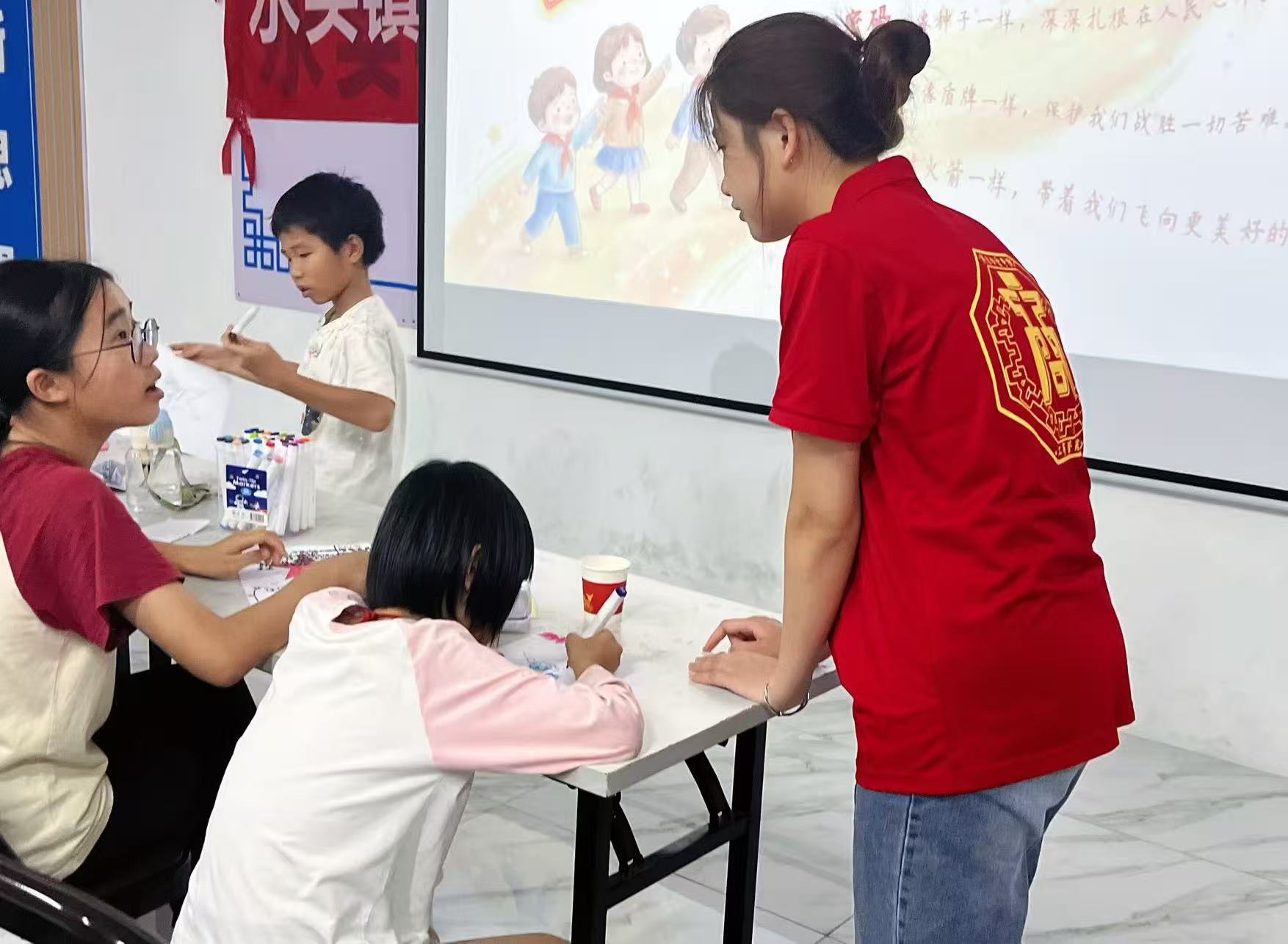 图为突击队成员与小朋友们一起交流红色手绘作品