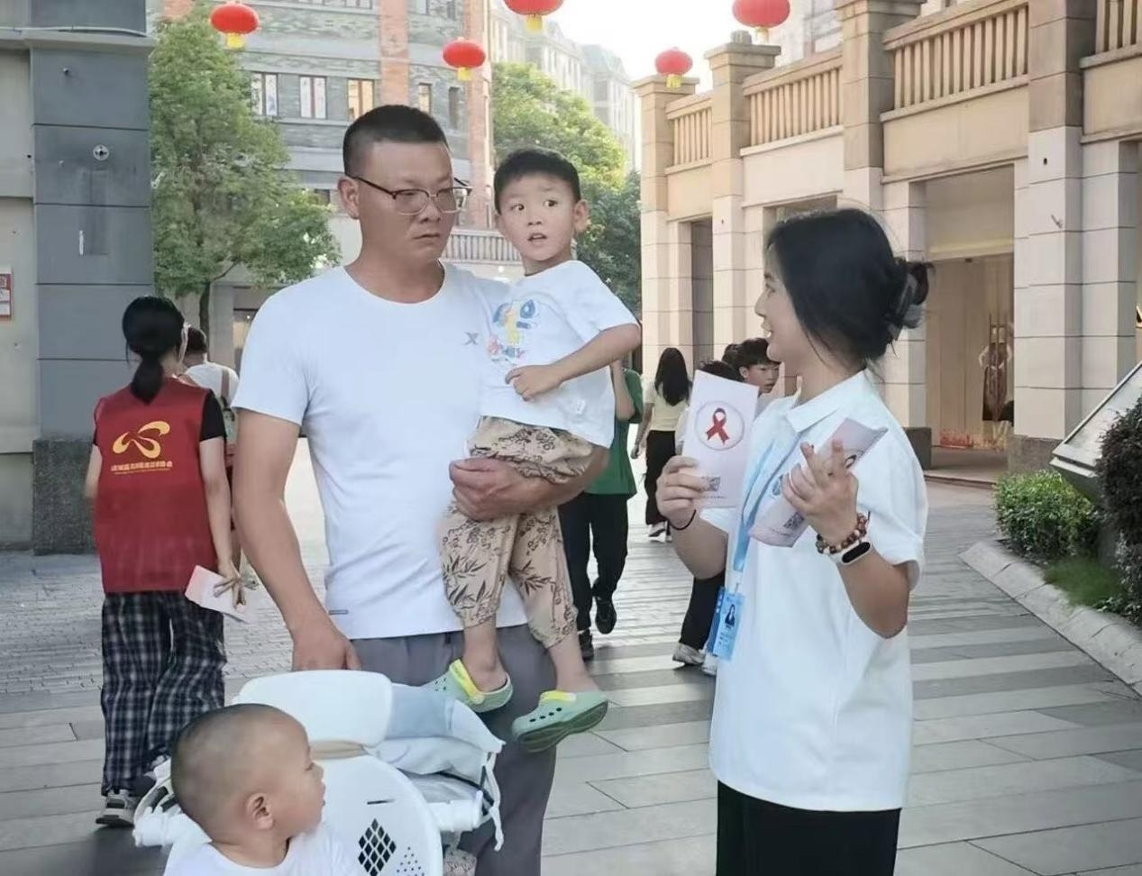 图五 实践队员给社区居民进行防艾宣讲（王恩恩 摄）