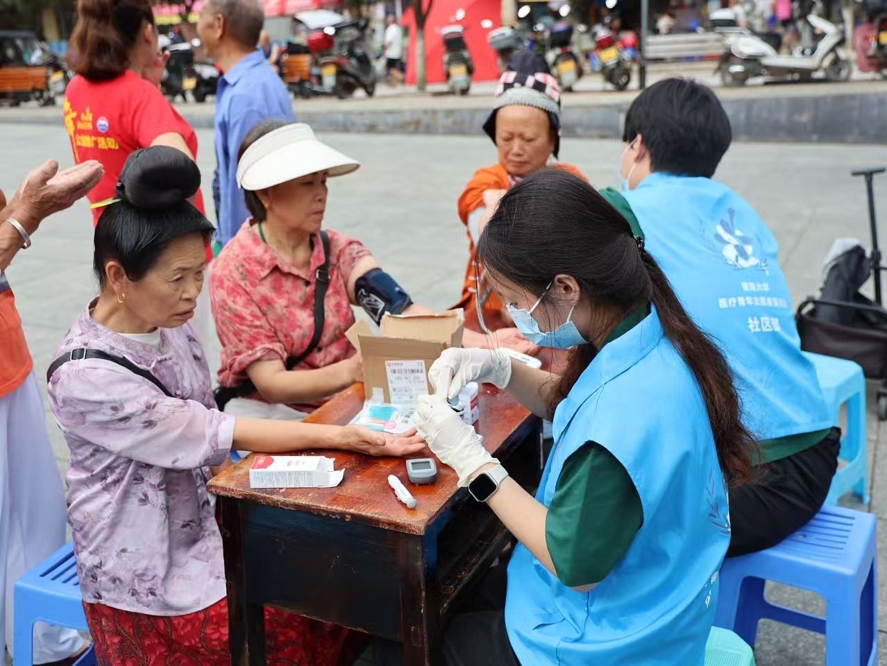 图为实践团成员在丹寨龙泉镇集市向当地居民提供义诊.jpg