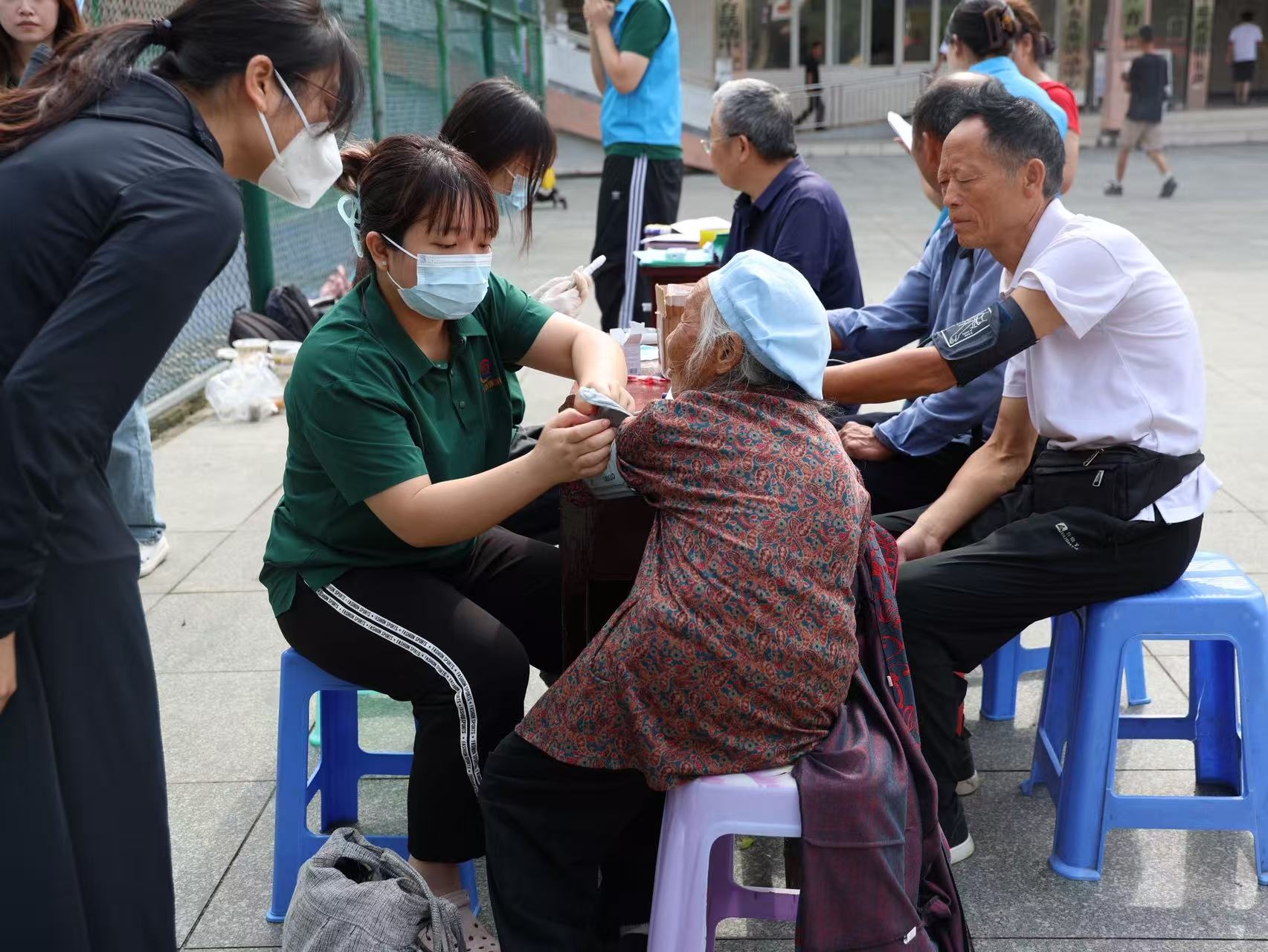 图为实践团成员在丹寨龙泉镇集市向当地居民提供义诊服务.jpg